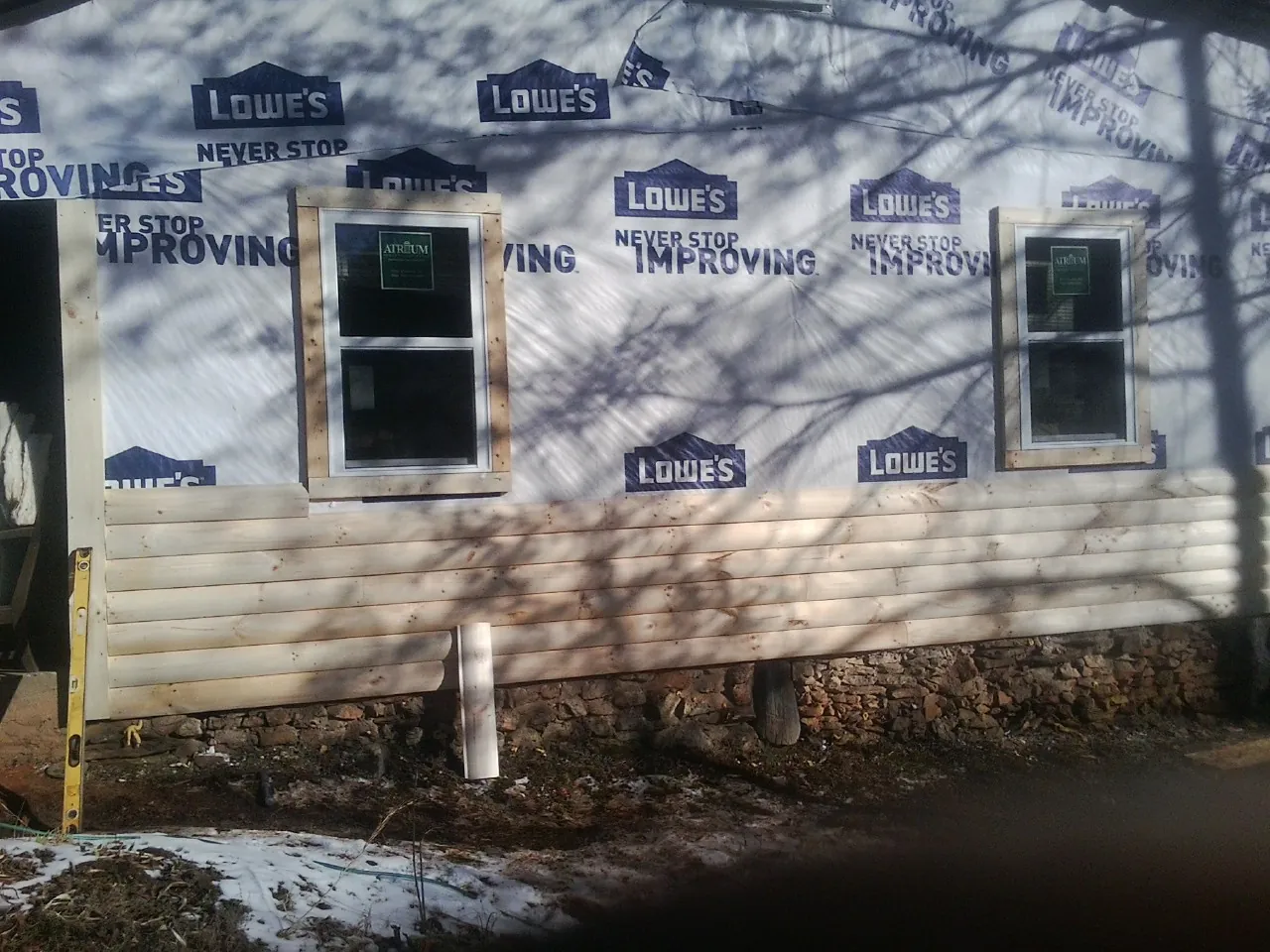 House wrap and new log siding going up on an exterior wall in Lexington